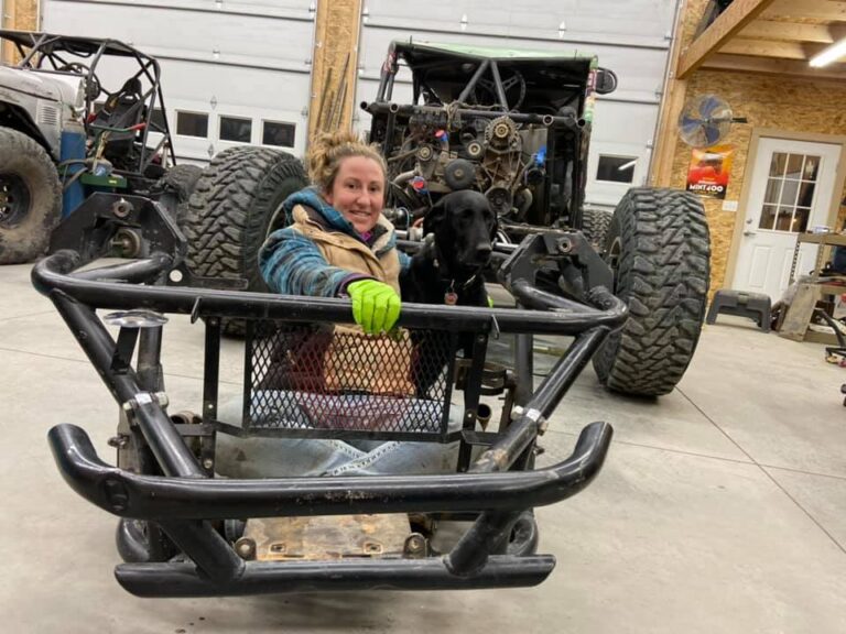 Kim working on her vehicle with her dog